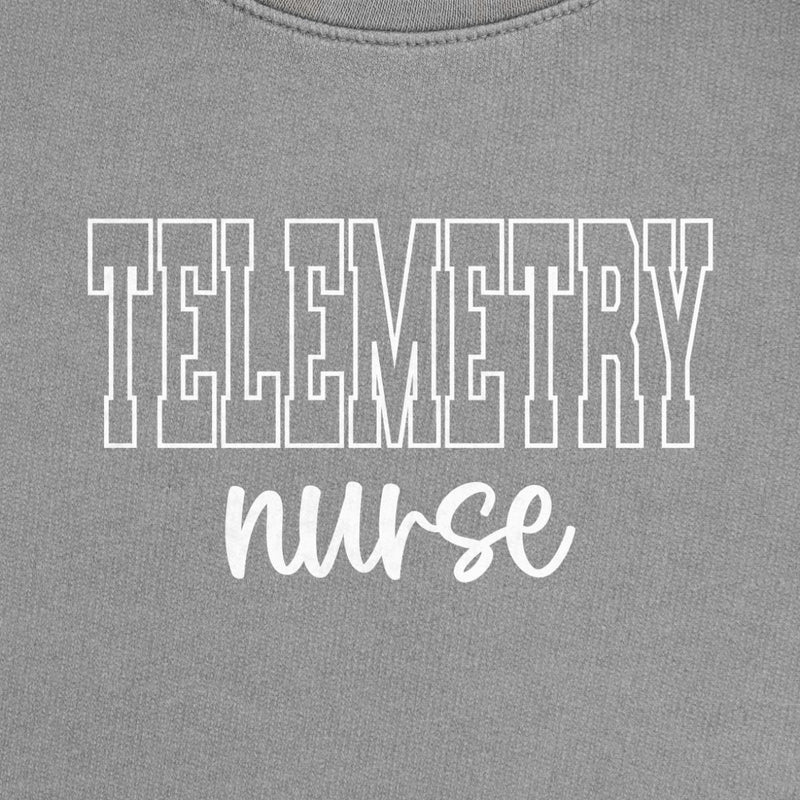 Telemetry Nurse Varsity Crewneck in Espresso, close-up of the white varsity-outline "TELEMETRY" with script "nurse" print on a folded crewneck