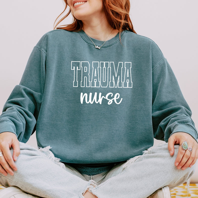 Model wearing the trauma nurse varsity sweatshirt with block letters and script