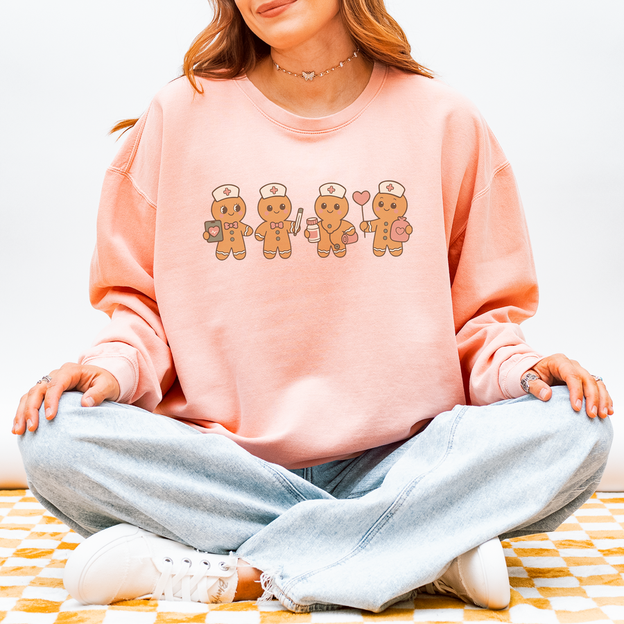 Model wearing the Gingerbread nurse Christmas sweatshirt with gingerbread nurses and stethoscopes
