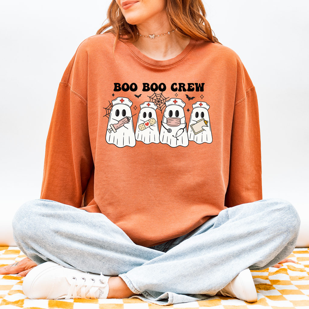 Model wearing Boo Boo Crew nurse ghost sweatshirt in Yam, front design of four nurse ghosts with syringe, bandage, stethoscope and clipboard, Comfort Colors 1466