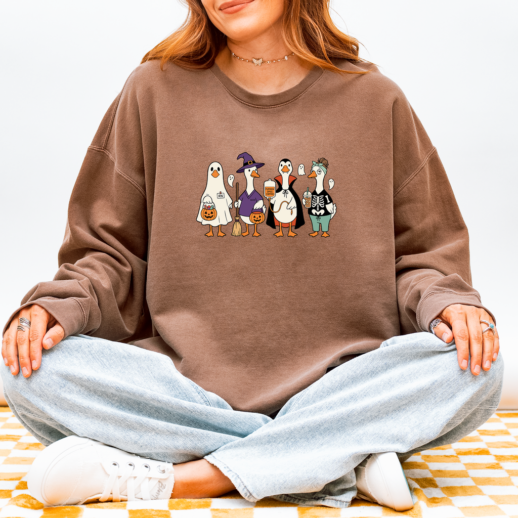Model wearing Halloween Nurse Geese sweatshirt with ghost, witch, Dracula and skeleton nurse geese, Comfort Colors 1466