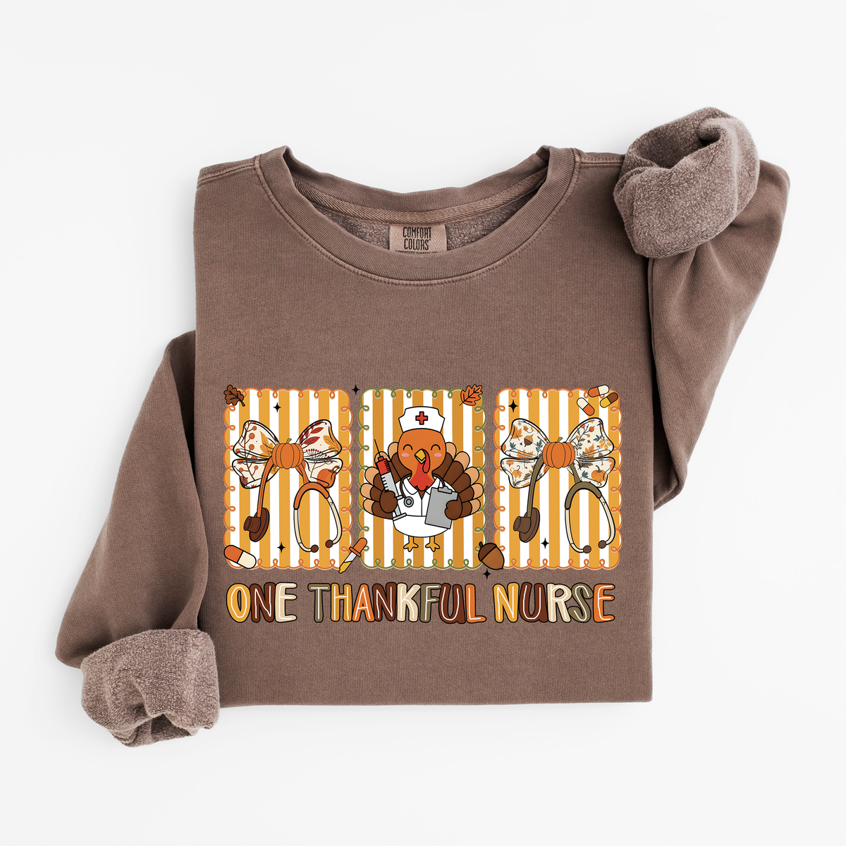 Espresso One Thankful Nurse Thanksgiving sweatshirt flat lay, One Thankful Nurse lettering with turkey nurse, fall bows and stethoscopes, Comfort Colors 1466