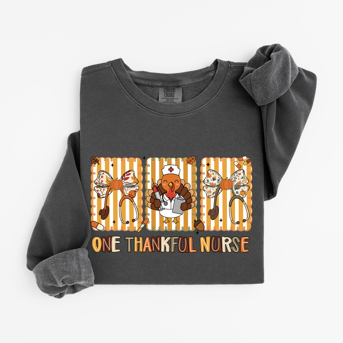 Pepper One Thankful Nurse Thanksgiving sweatshirt flat lay, One Thankful Nurse lettering with turkey nurse, fall bows and stethoscopes, Comfort Colors 1466