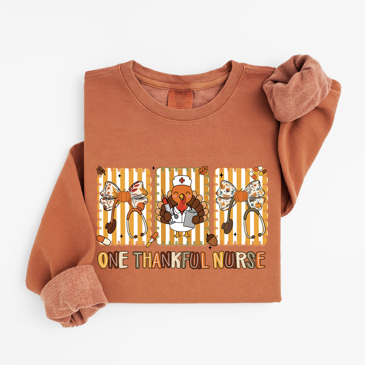 Yam One Thankful Nurse Thanksgiving sweatshirt flat lay, One Thankful Nurse lettering with turkey nurse, fall bows and stethoscopes, Comfort Colors 1466