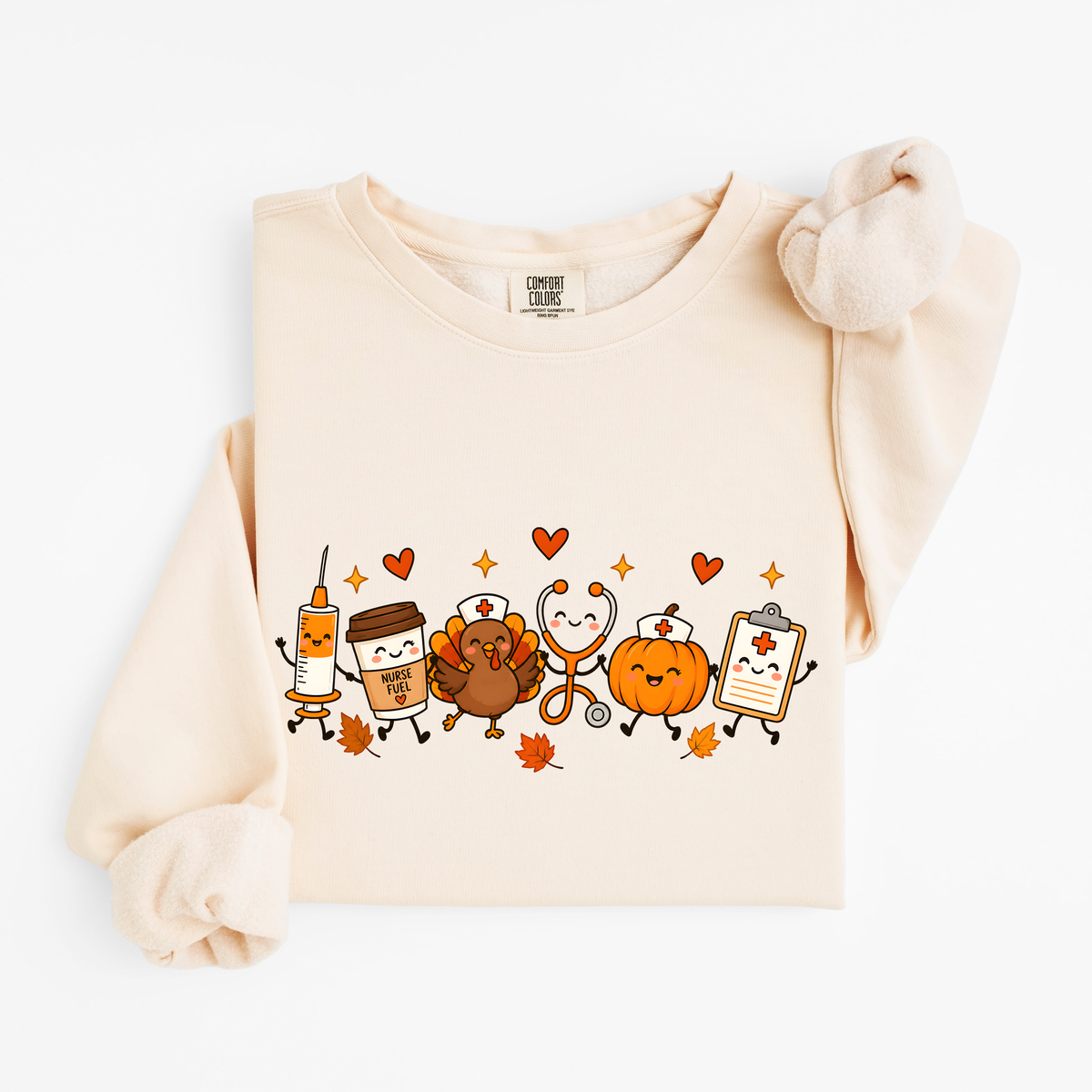 Ivory Thanksgiving Nurse Friends sweatshirt flat lay, turkey, pumpkin, Nurse Fuel coffee, syringe, stethoscope and clipboard characters, Comfort Colors 1466