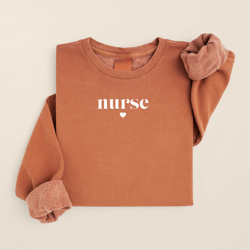 Minimalist Script Nurse Sweatshirt in Yam, folded flat on a warm oat background