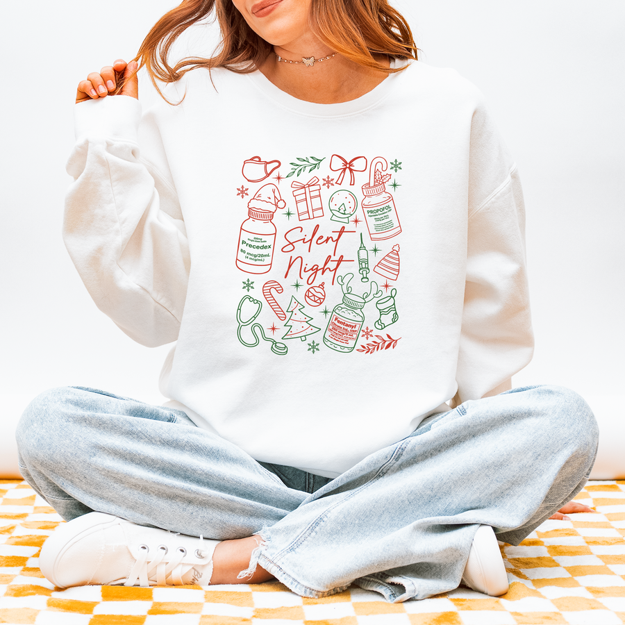 Model wearing the Silent Night nurse Christmas sweatshirt with red and green sleepy meds design
